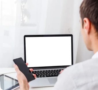 Back view of male person sitting front open laptop